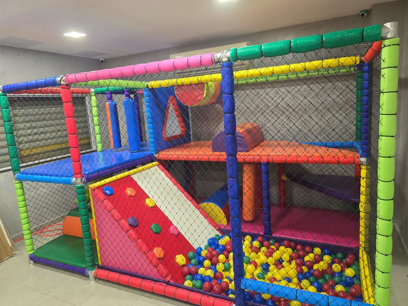Brinquedão com parede de escalada, ball pit e nets coloridas