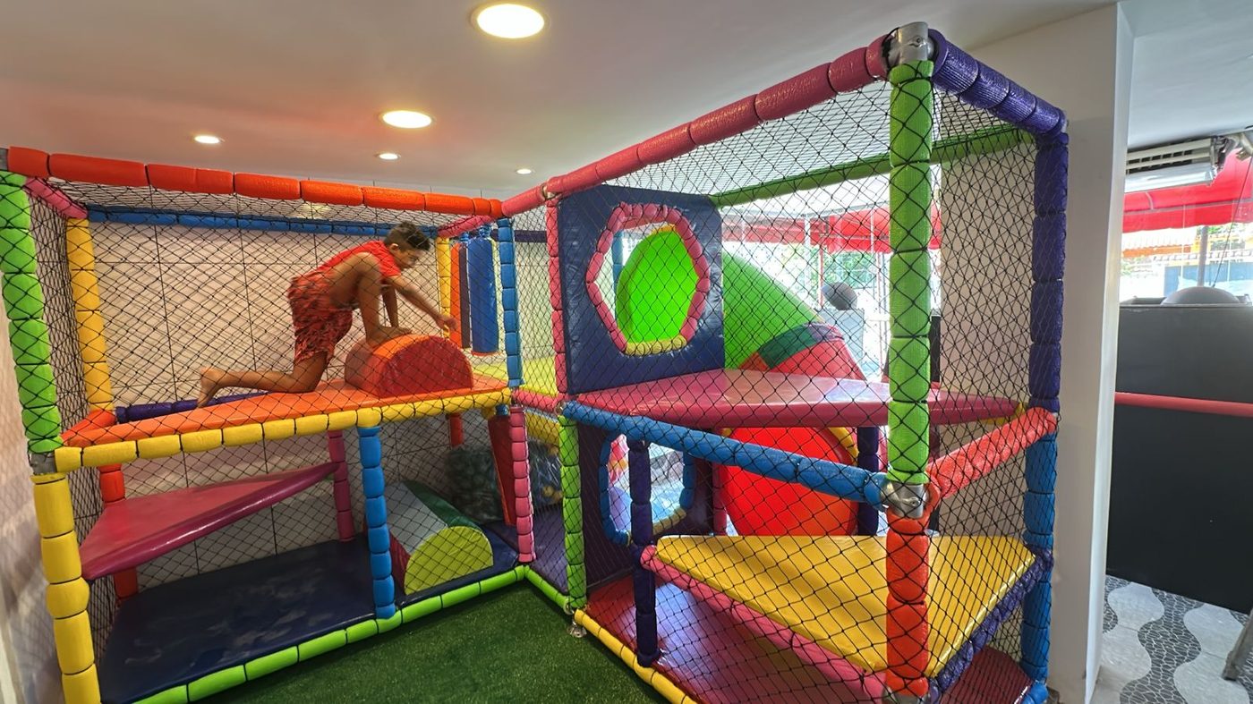 Criança brincando em plataforma colorida do brinquedão